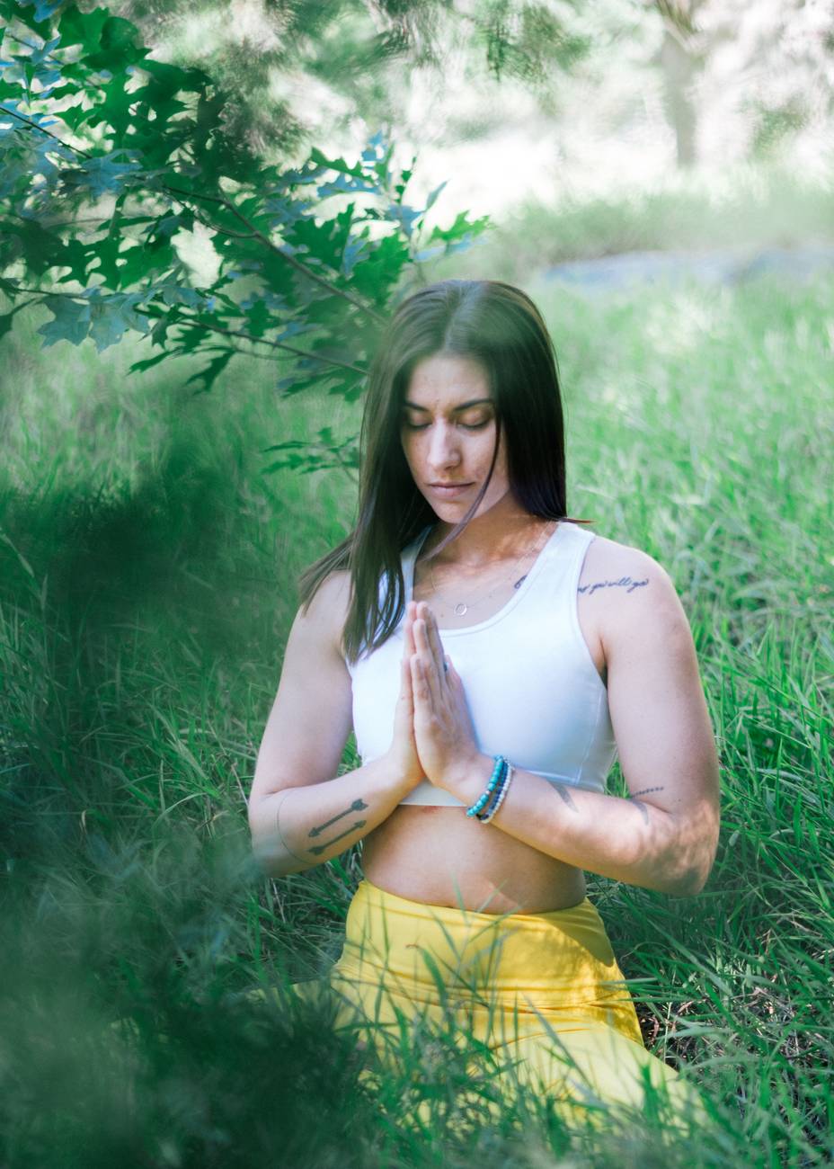 photo of woman practicing yoga on grass field